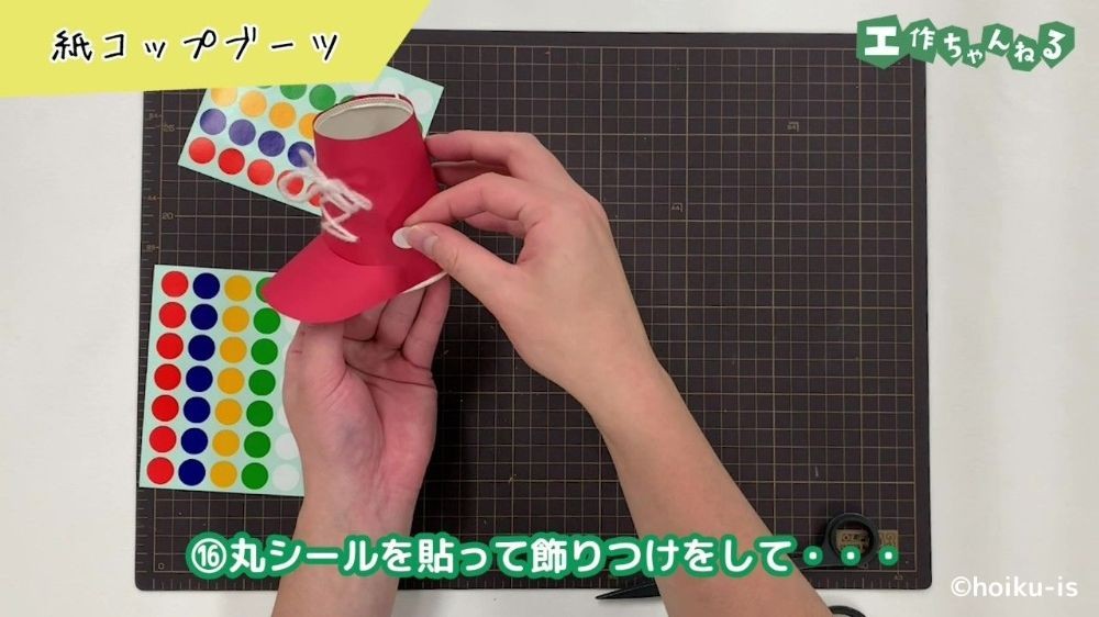紙コップで作ったブーツにシールを貼る手元