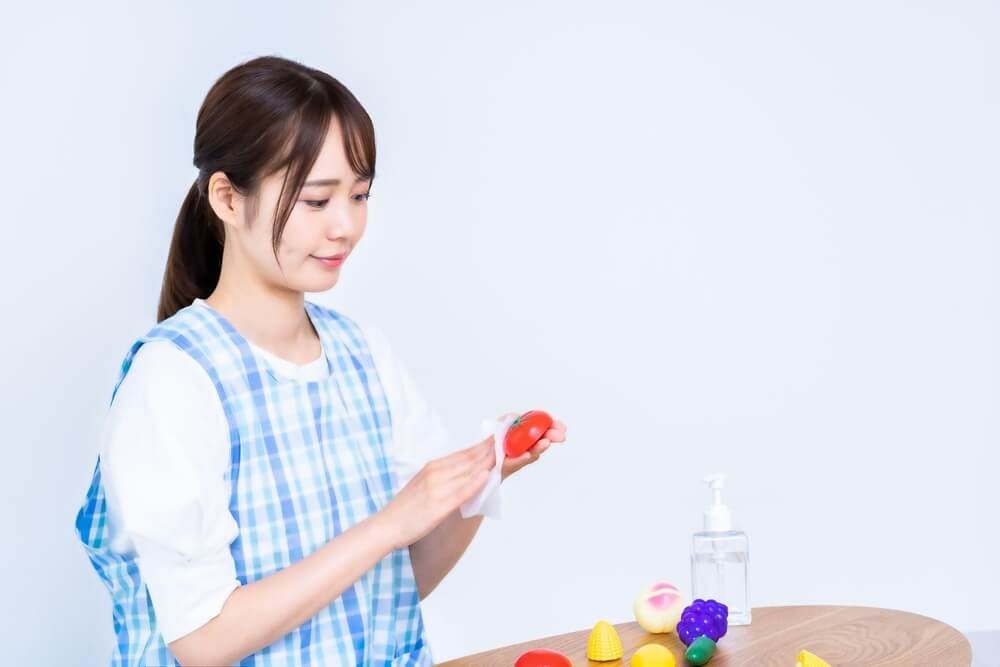 おもちゃを消毒する保育士