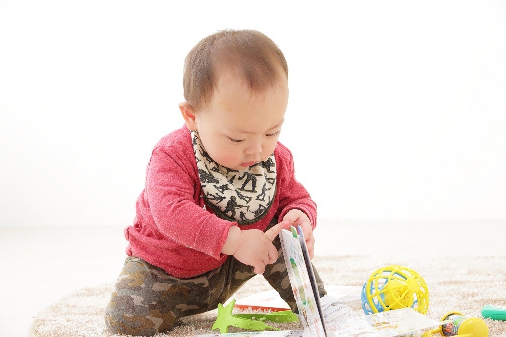 絵本をめくろうとしている子ども