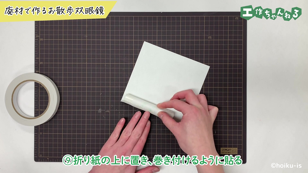トイレットペーパーの芯に折り紙を巻き付けている手元