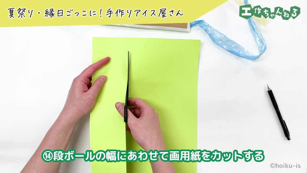 ハサミで画用紙をカットしている手元