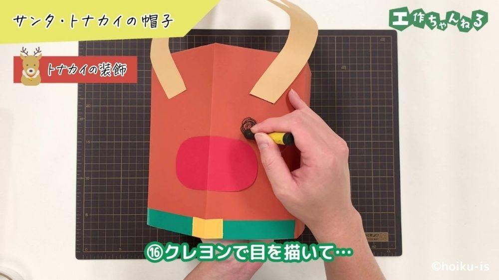 クレヨンでトナカイの目を描いている手元