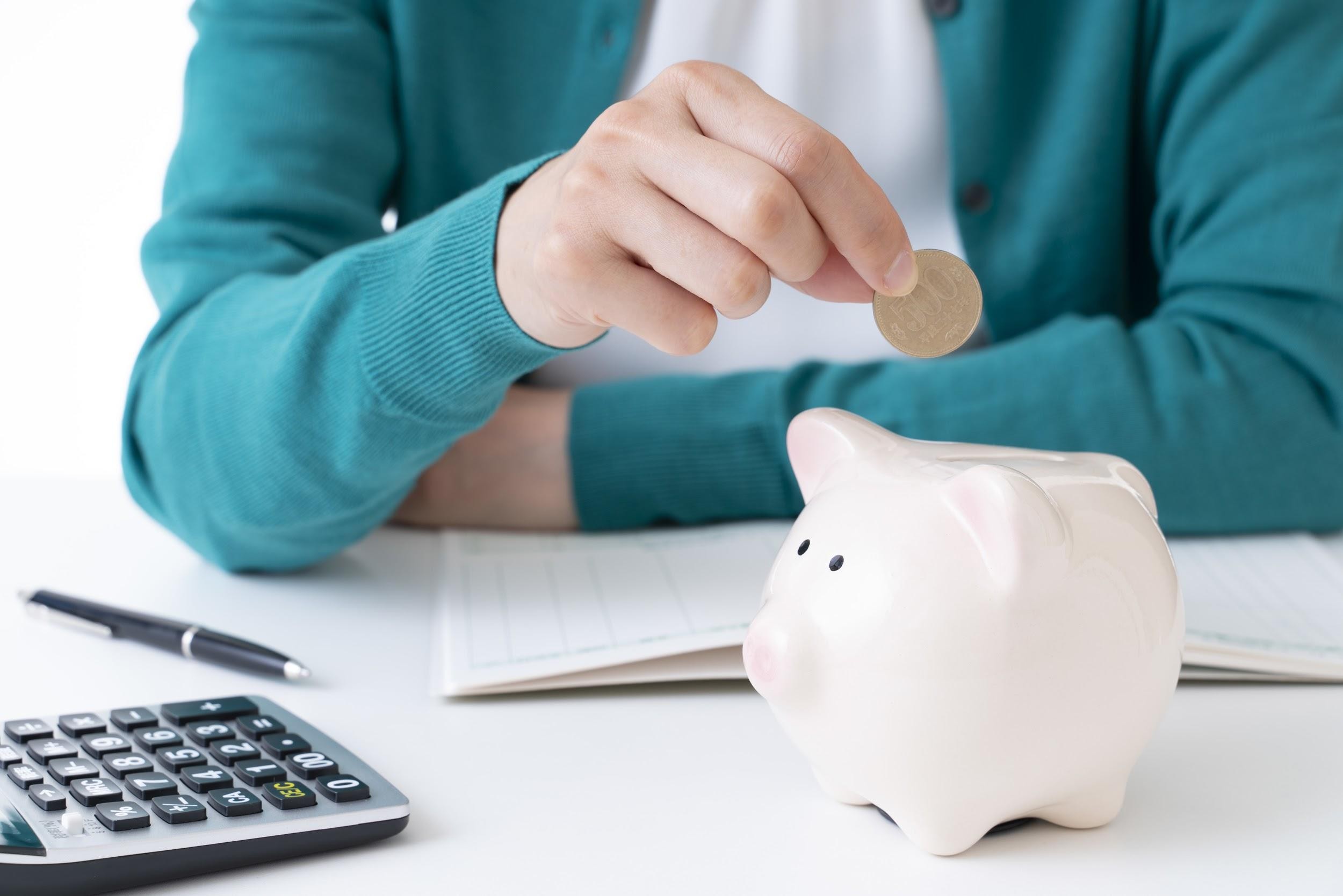貯金箱にお金を入れているところ