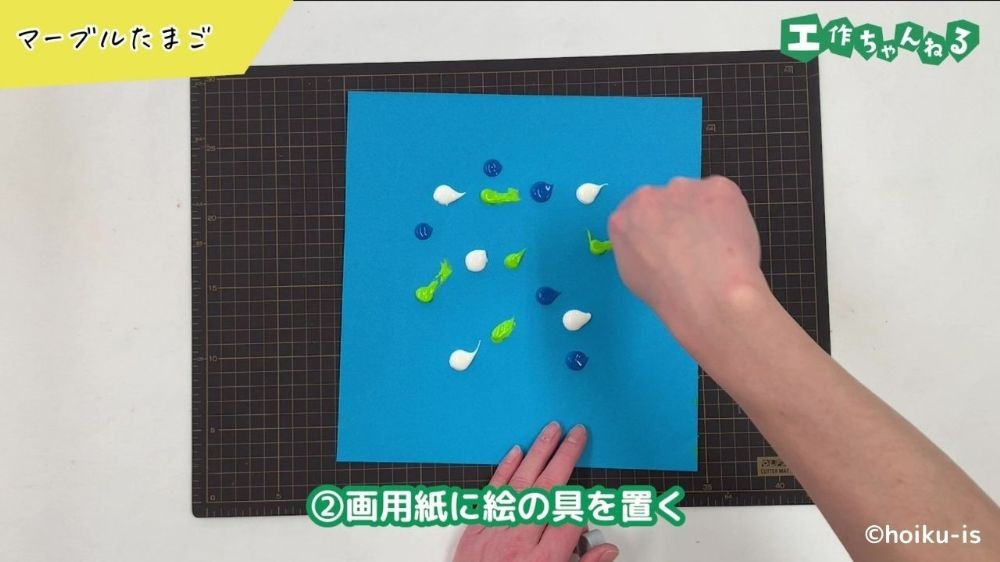 画用紙に絵の具を出している手元