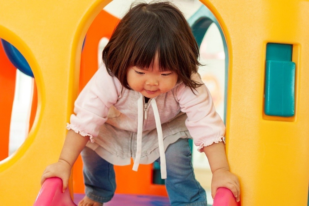 滑り台から滑ろうとしている子ども