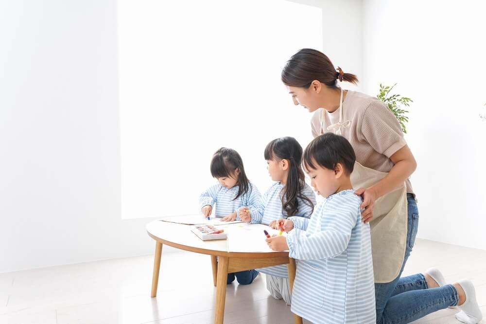 保育士と遊ぶ子どもたち