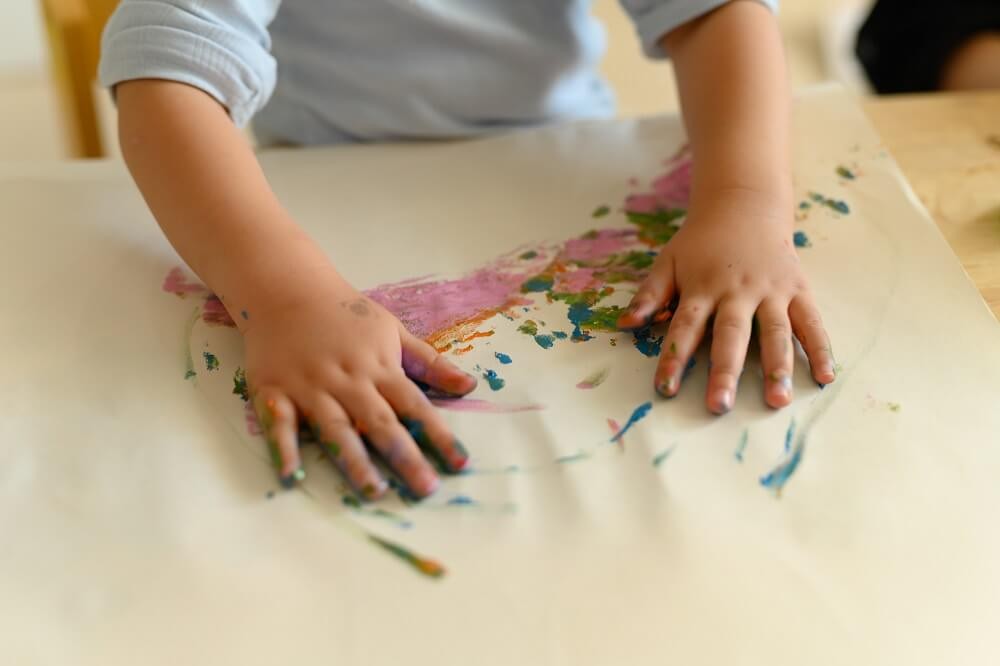 絵の具あそびをする子どもの手
