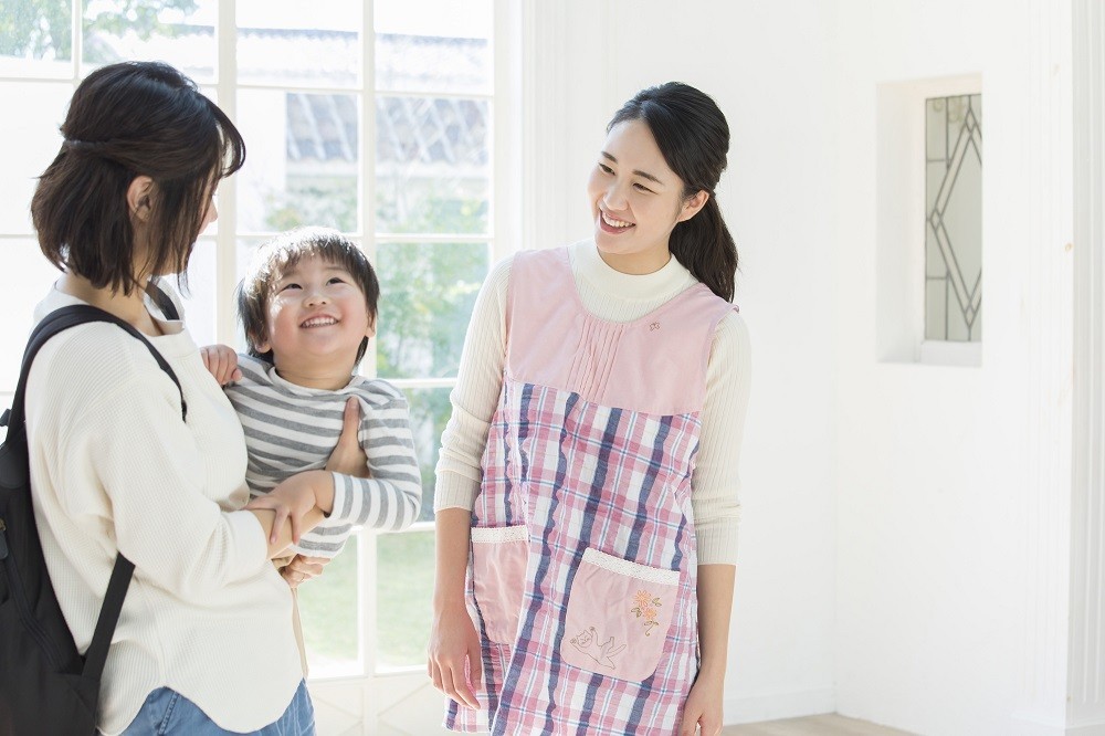 保護者と会話を交わす保育士