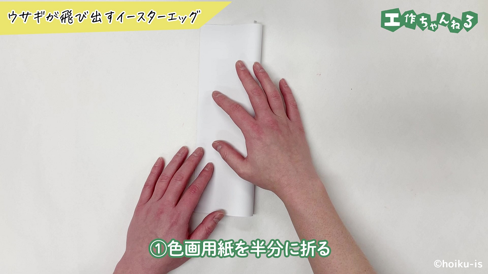 白い画用紙を半分に折っている手