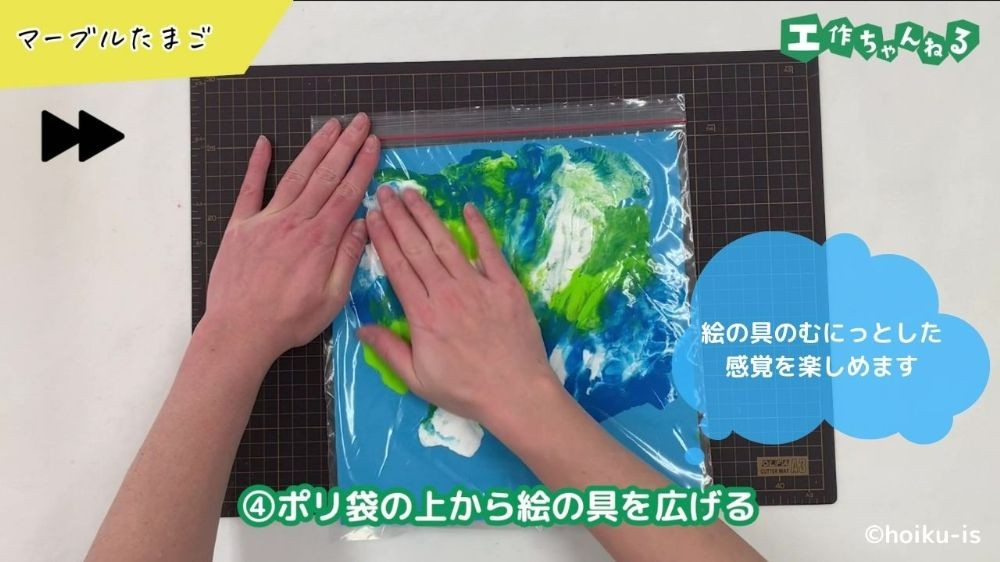 手で絵の具を広げている手元