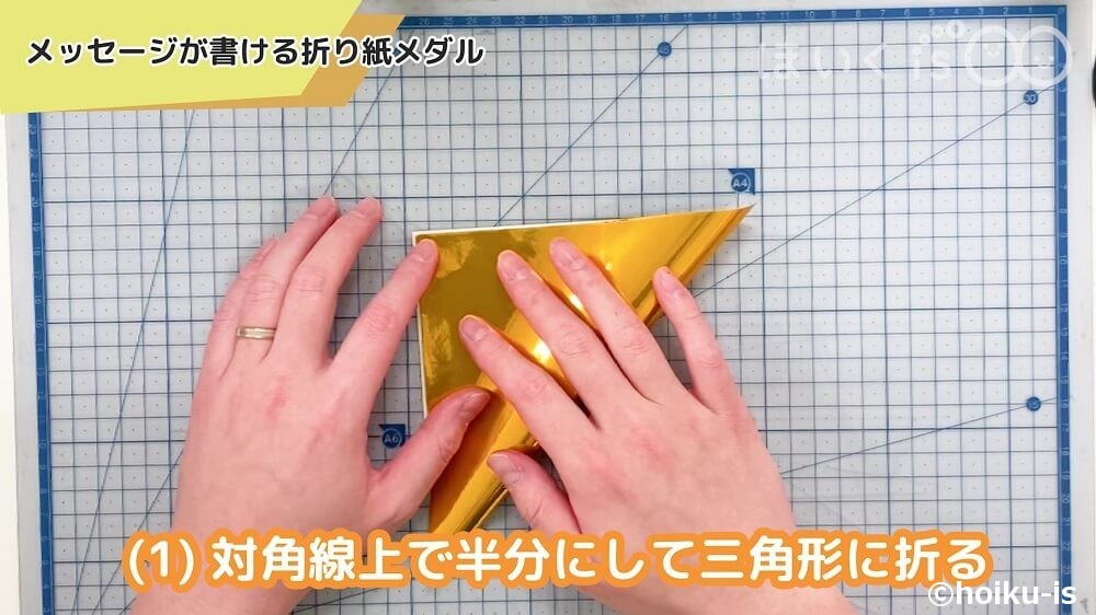 対角線上で半分にして三角形に折る