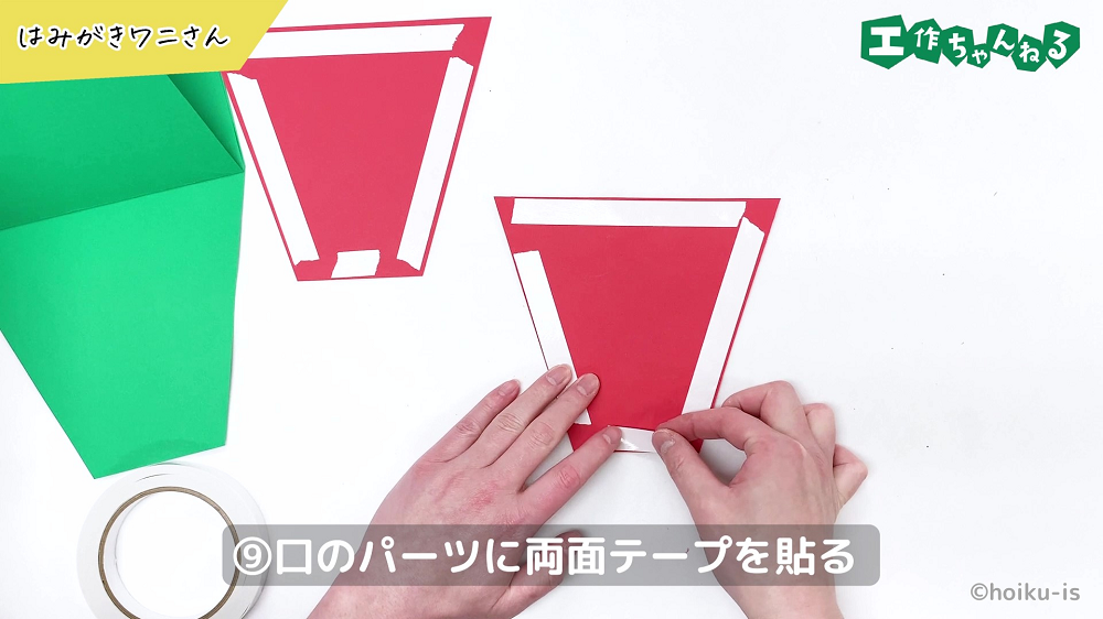 赤い画用紙に両面テープを貼り付けている手元