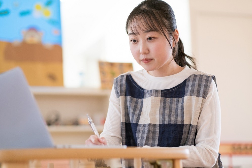 書類を作成している保育士