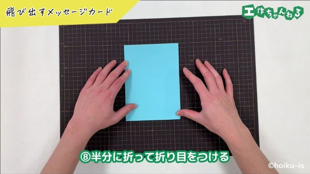 画用紙を2つ折りにしている手元