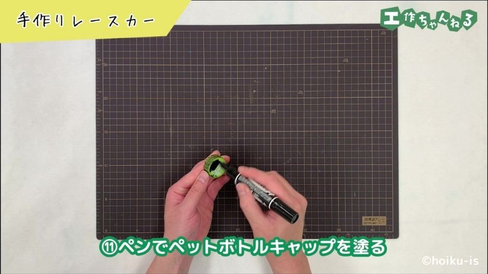 油性ペンでペットボトルキャップを塗っている手元