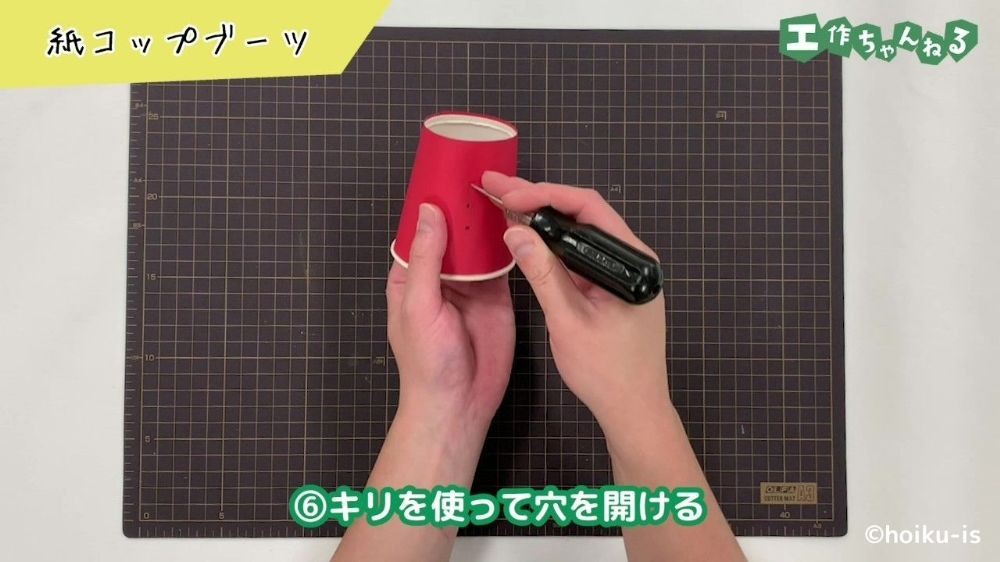 キリで穴を開けている手元