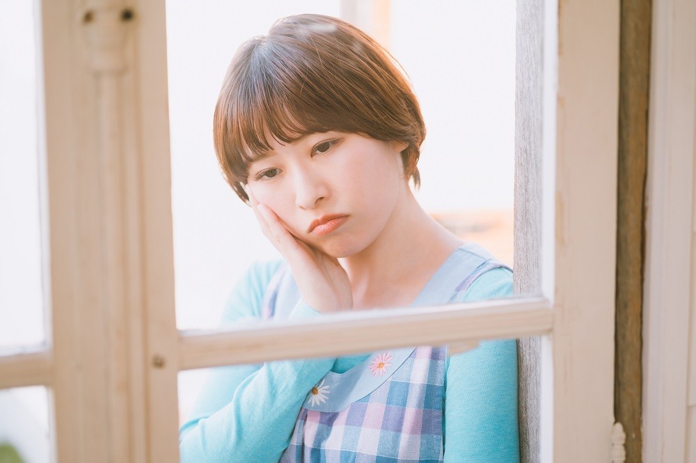 思い悩んでいる様子の保育士