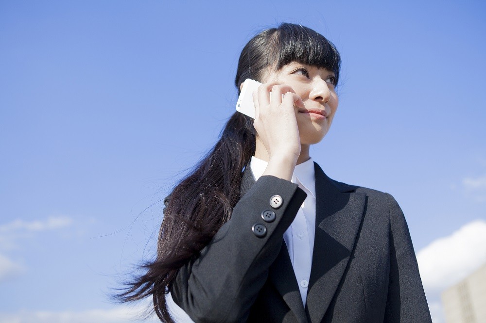 スマートフォンで電話をしている就活生