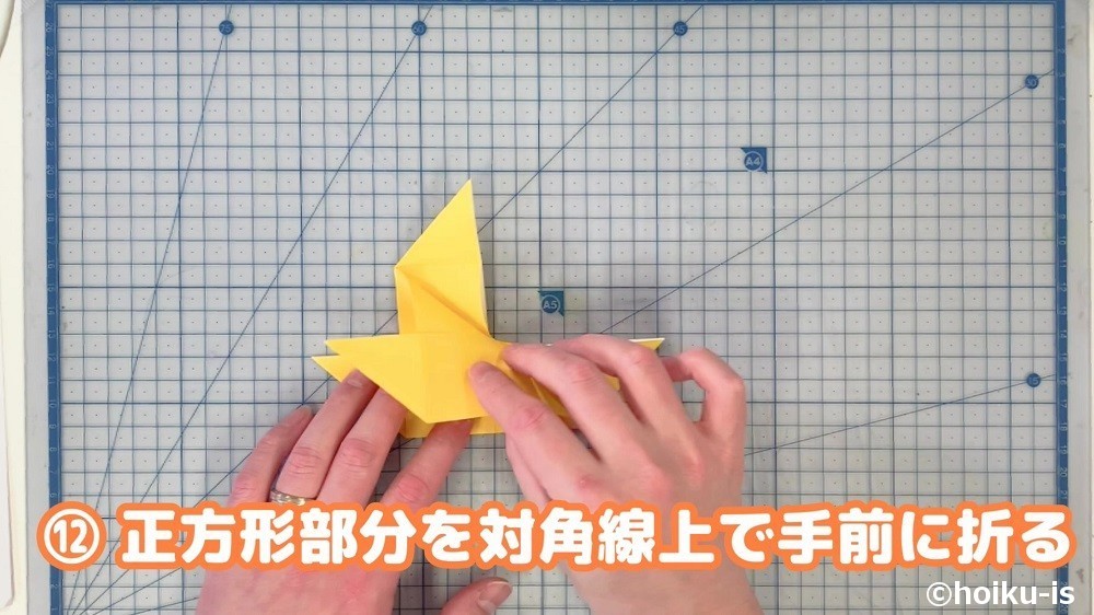 正方形部分を対角線上で手前に折る