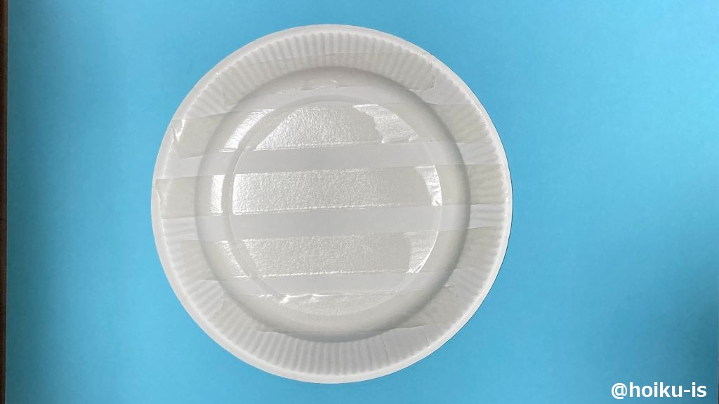 紙皿の裏面に両面テープを貼り、剥離紙をはがす