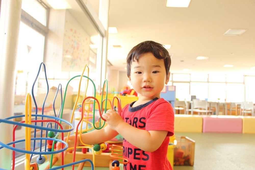 保育室内にある遊具で遊ぶ男の子