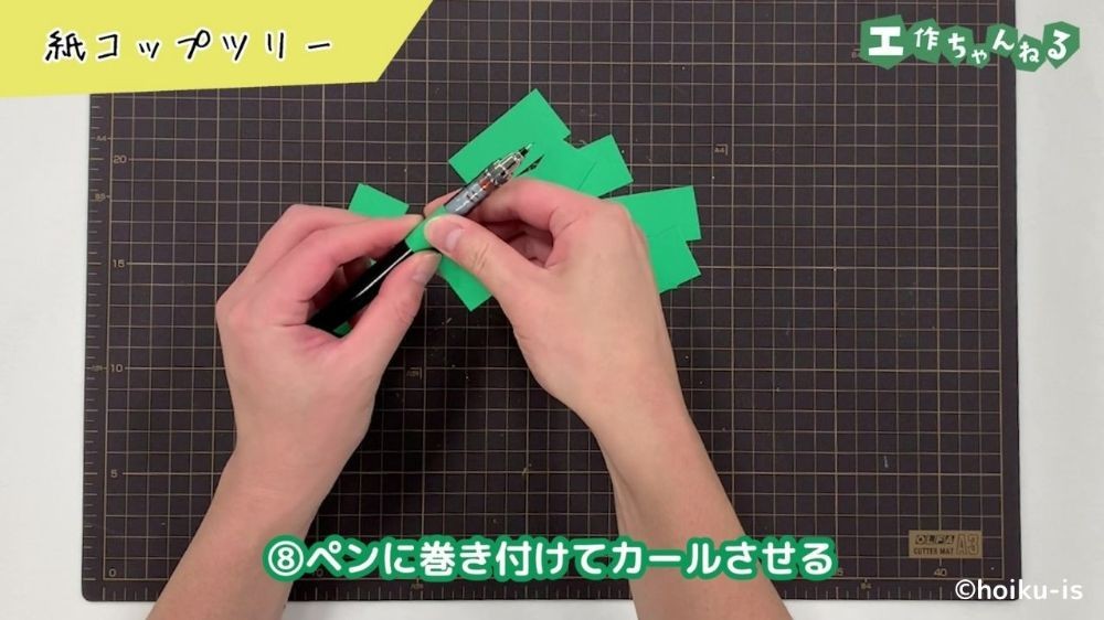 画用紙をペンで巻いている手元