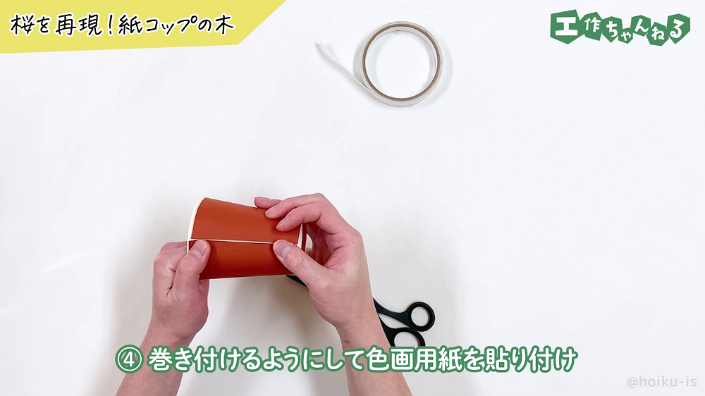 紙コップに茶色の画用紙を巻き付けている様子