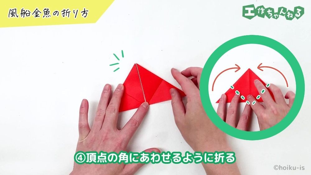 折り紙の角をあわせて折っている手元