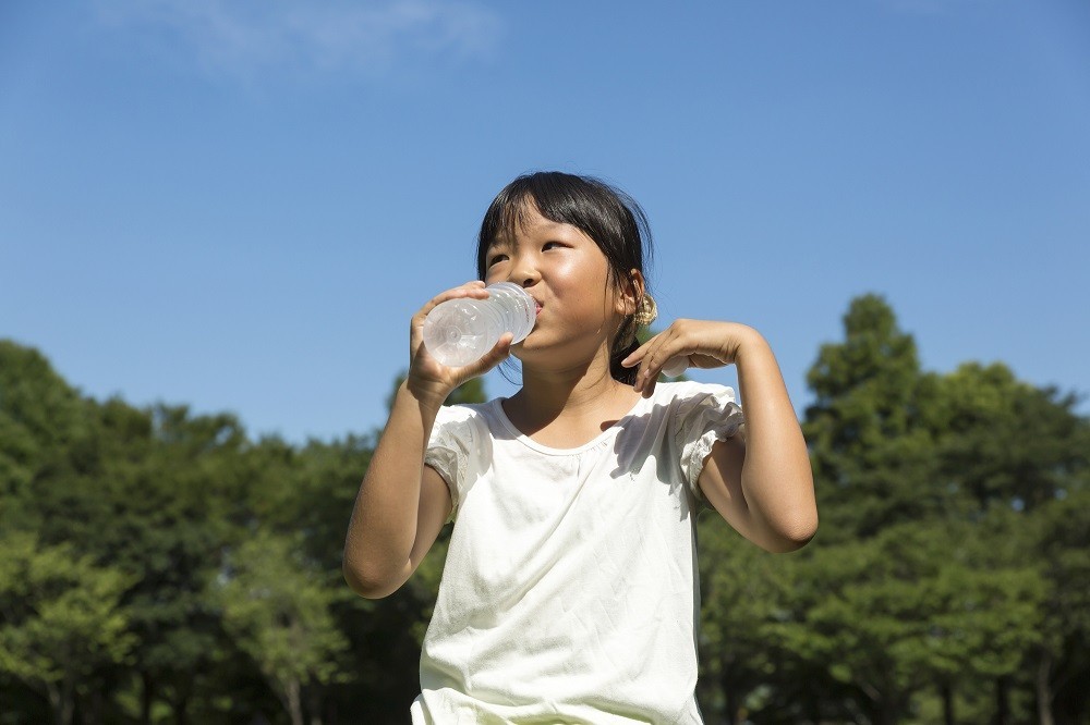 汗をかきながら水を飲んでいる女の子