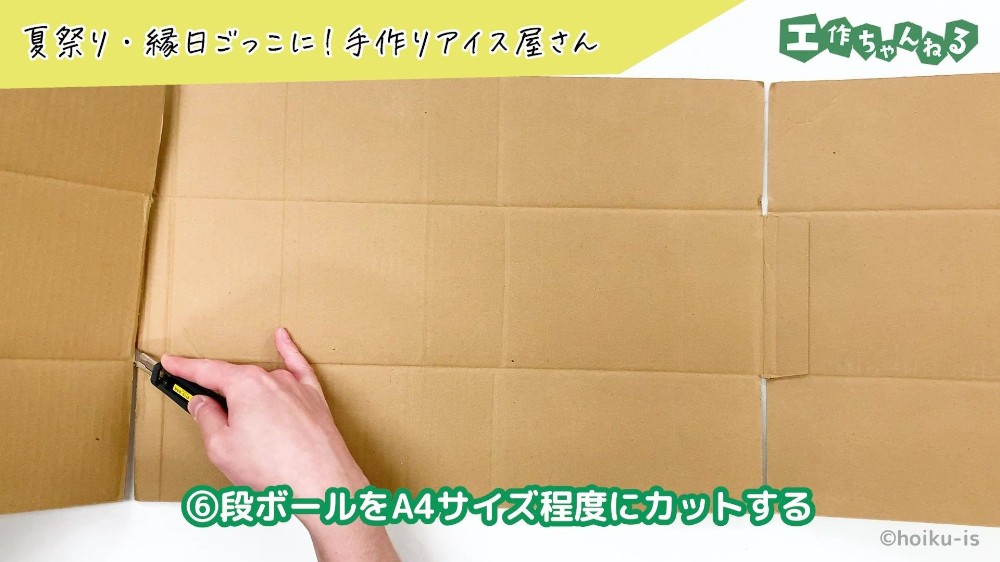 カッターで段ボールを切っている手元