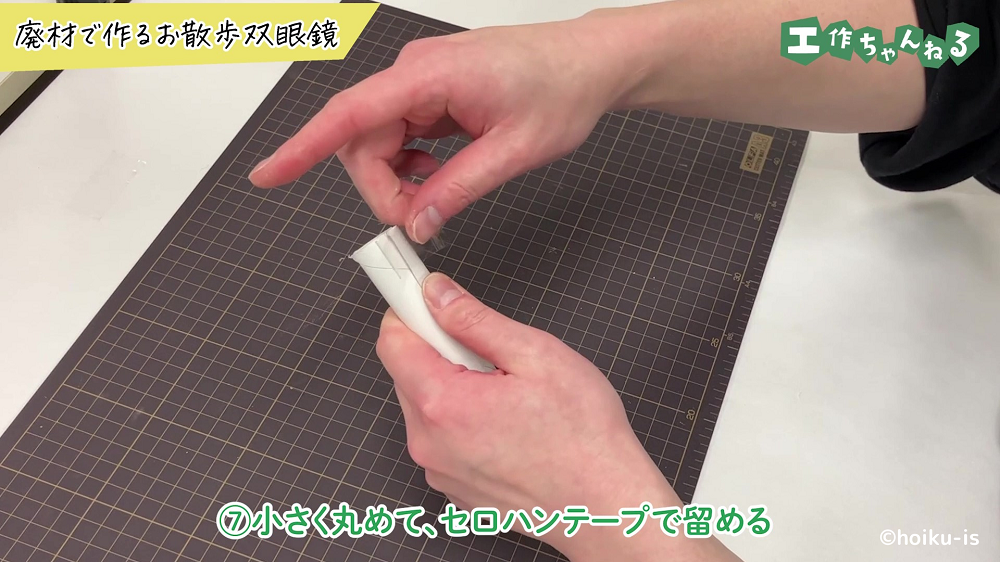 トイレットペーパーの芯を小さく丸めている手元