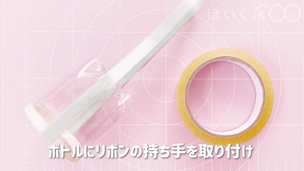ペットボトルの本体にリボンの持ち手をセロハンテープで取り付け