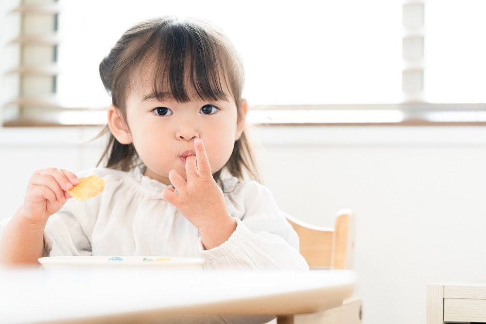 椅子に座ってご飯を食べている女の子