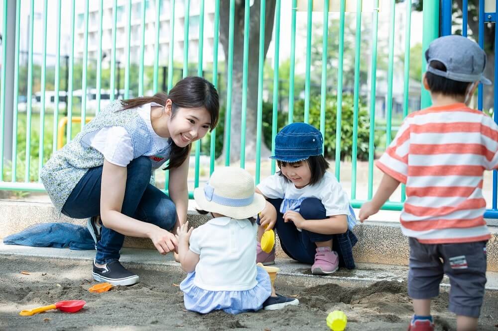 外遊びをする子どもたちと保育士