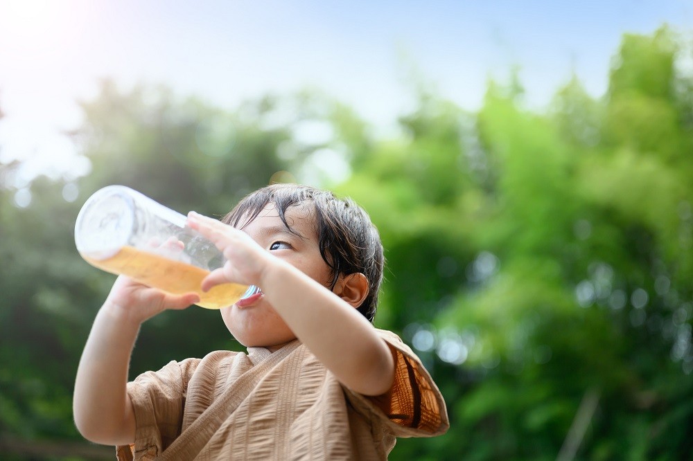 屋外で水分補給をしている園児