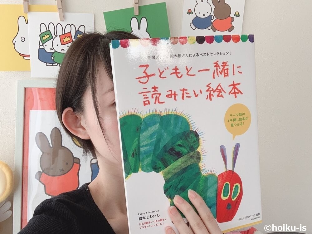 書籍「子どもと一緒に読みたい絵本」を持つ女性