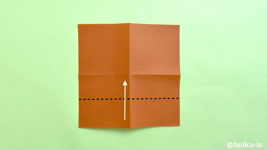 裏返し、図の点線に沿って、中心の折り目に向かって谷折りにします。