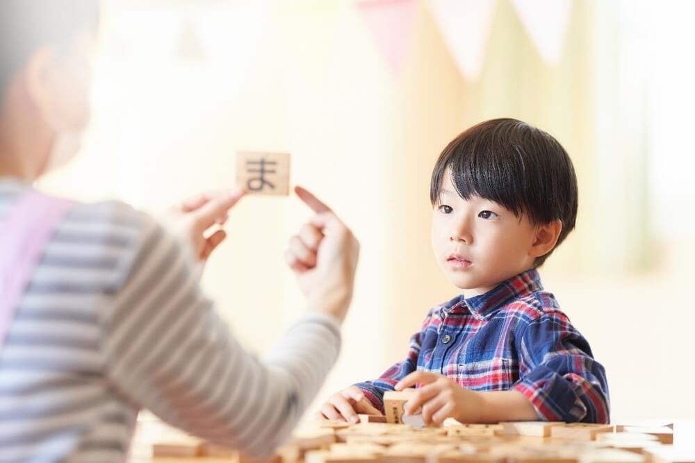 ひらがなを教わる子ども