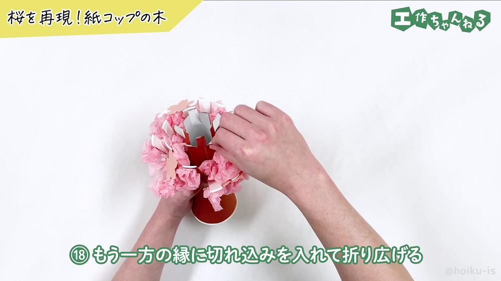 トイレットペーパーの芯の切れ込み部分を外に広げている様子