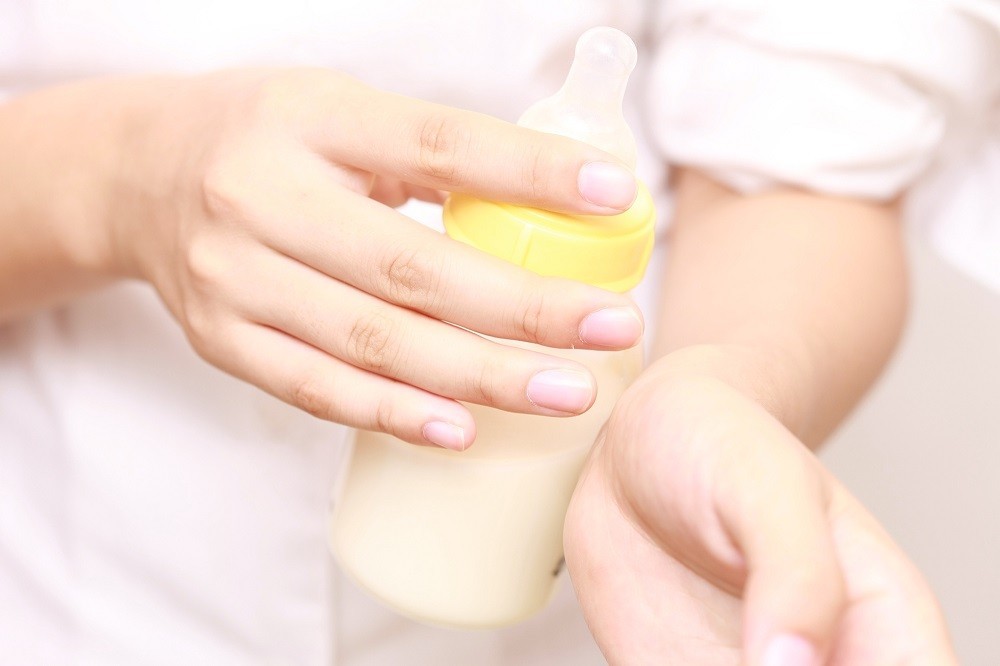 哺乳瓶を腕に当てて温度を確認しているところ