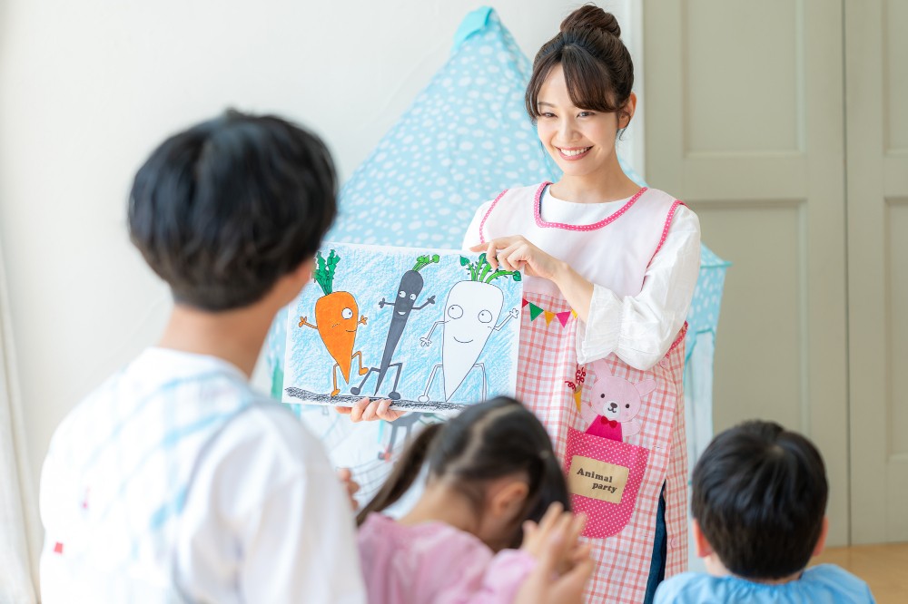 紙芝居をする保育士