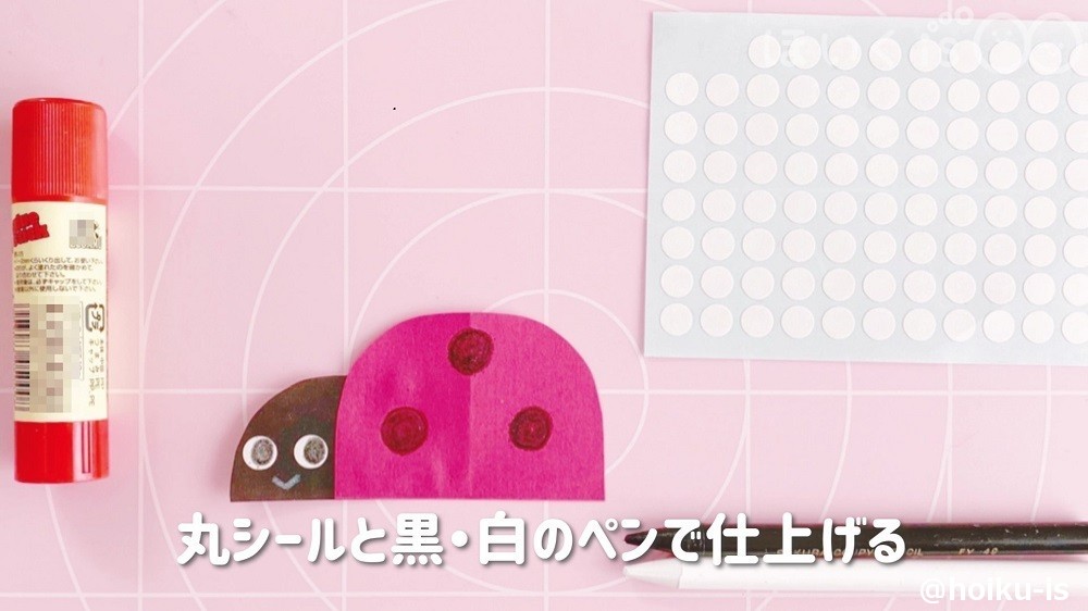 丸シールと黒・白のペンで顔を描いているところ