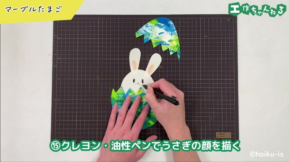 ペンでうさぎの顔を描いている手元