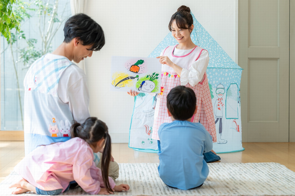 紙芝居読む保育士と子ども
