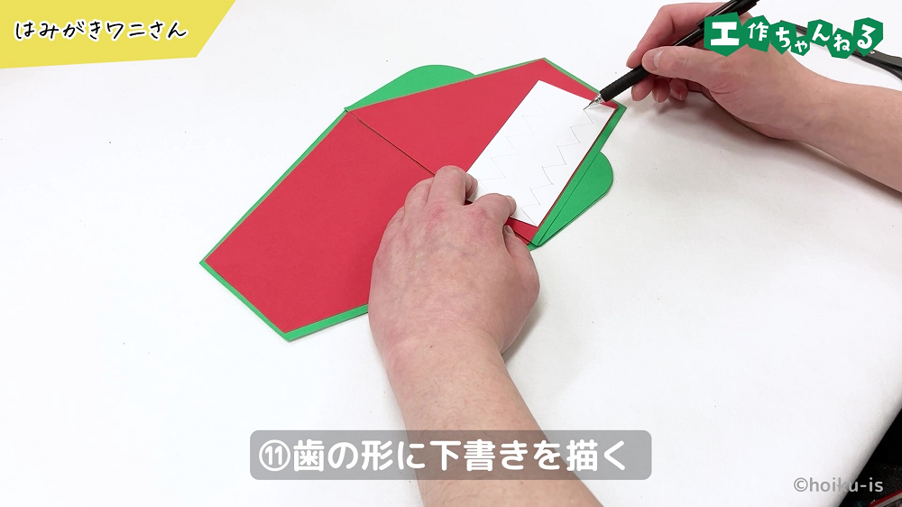 鉛筆でギザギザの歯を描いている手元