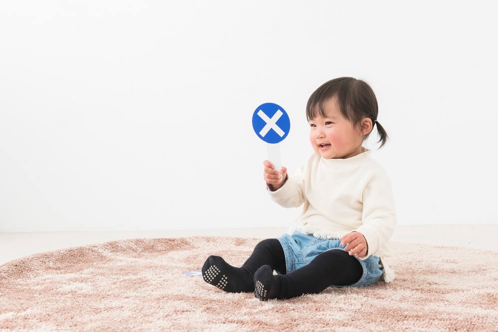 バツマークを持つ女の子の画像