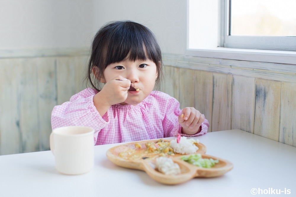 保育園で給食を食べている女の子