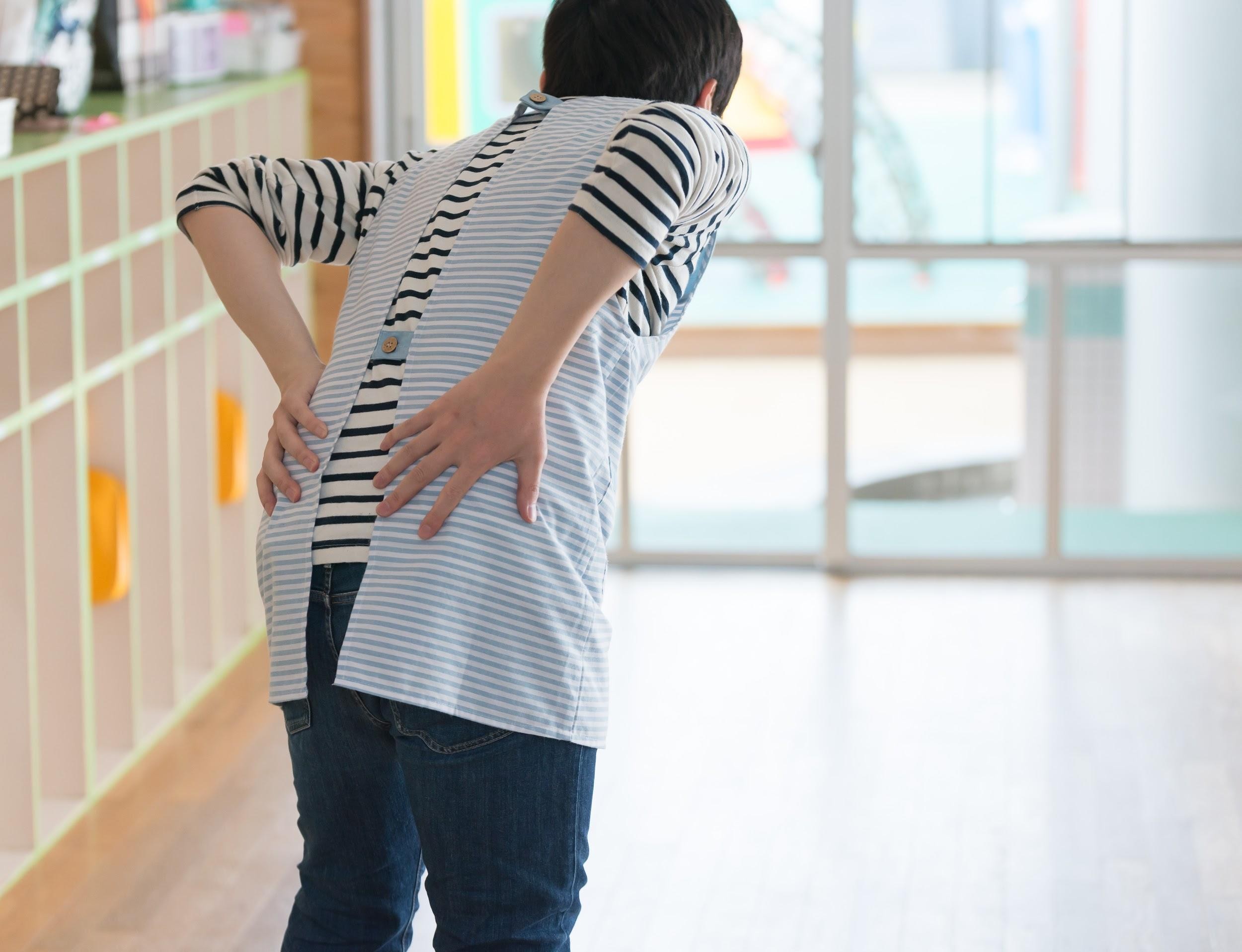 腰に手を当てる男性保育士