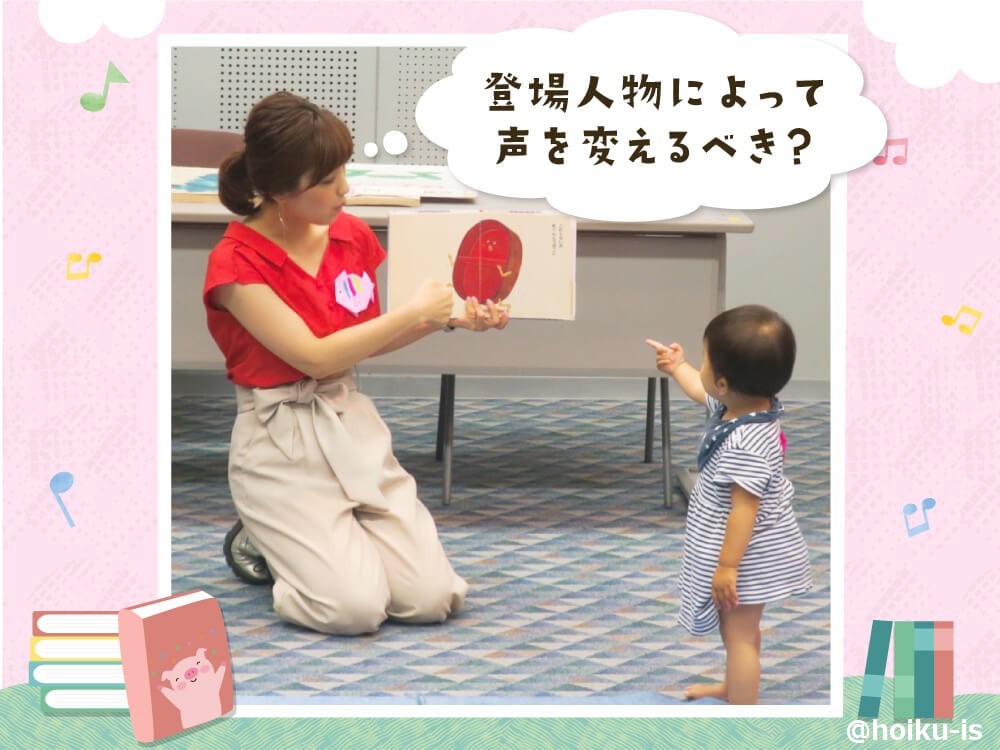 乳児に絵本を見せる保育士