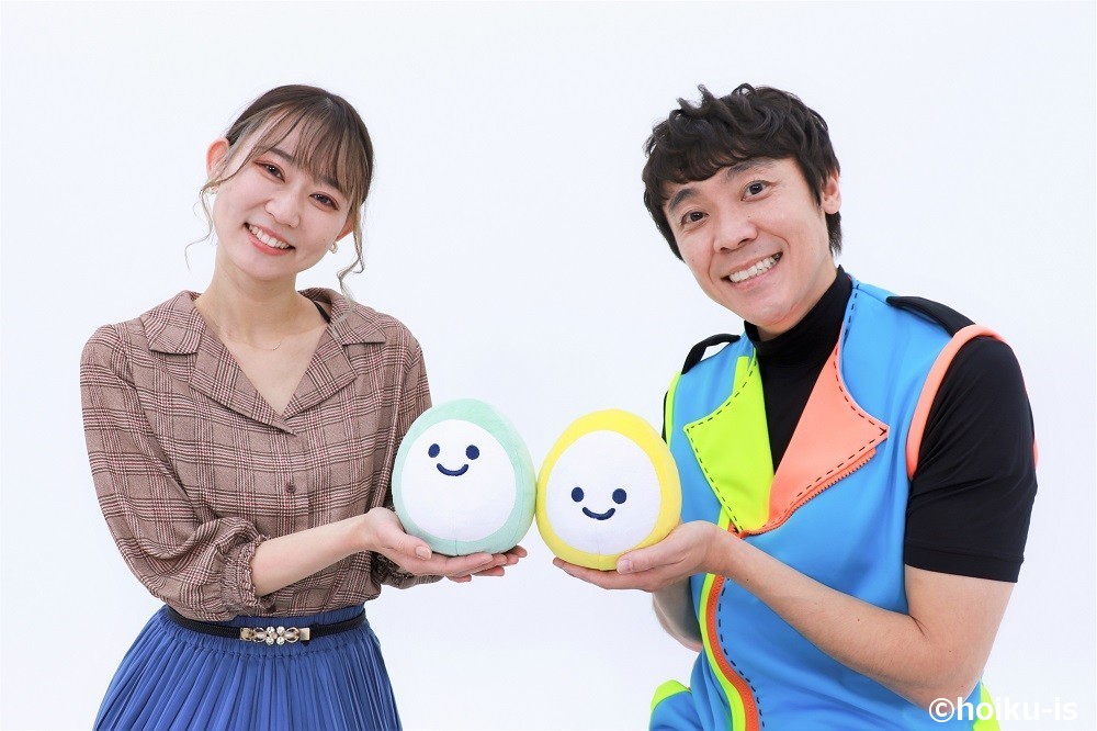 ほいくisのキャラクターを持ってポーズを取る体操の「よしお兄さん」とまゆか先生